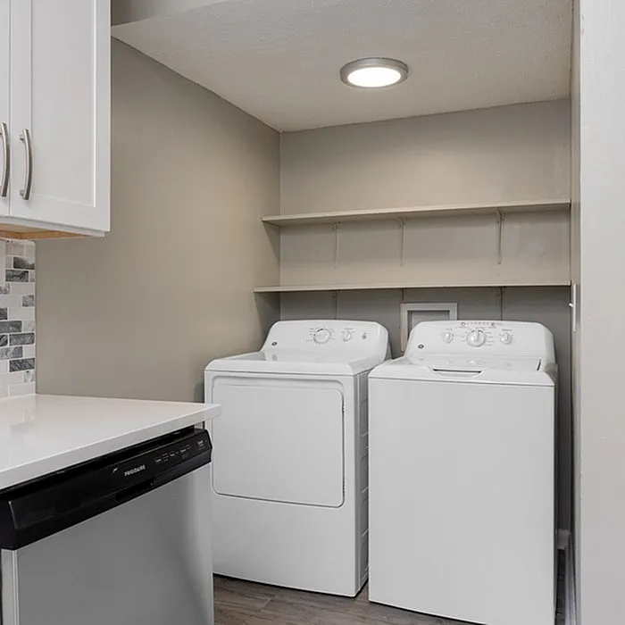 Modern laundry room with sleek washer and dryer, elegant cabinetry, and efficient storage solutions.
