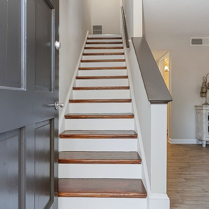 Inviting staircase with elegant wood steps leading to a bright upper floor in a modern home entrance.