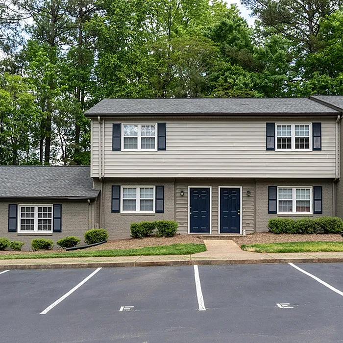 Charming two-story duplex surrounded by lush greenery, featuring plentiful natural light and inviting curb appeal.