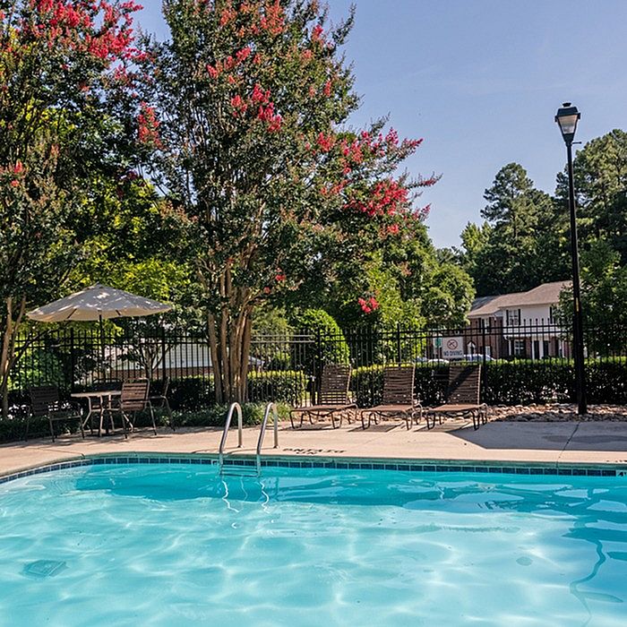 Charming outdoor pool area surrounded by lush greenery and comfortable lounge chairs, perfect for relaxation.