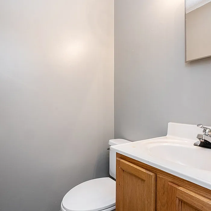 Modern bathroom with sleek design, featuring a wood-accented vanity and elegant fixtures.