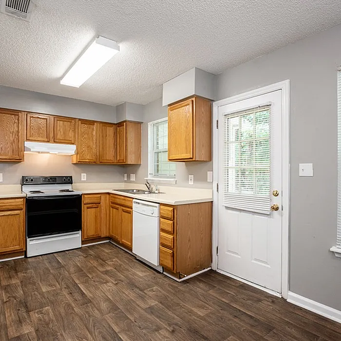 Charming kitchen with elegant wood cabinets, modern appliances, and inviting natural light through large windows.