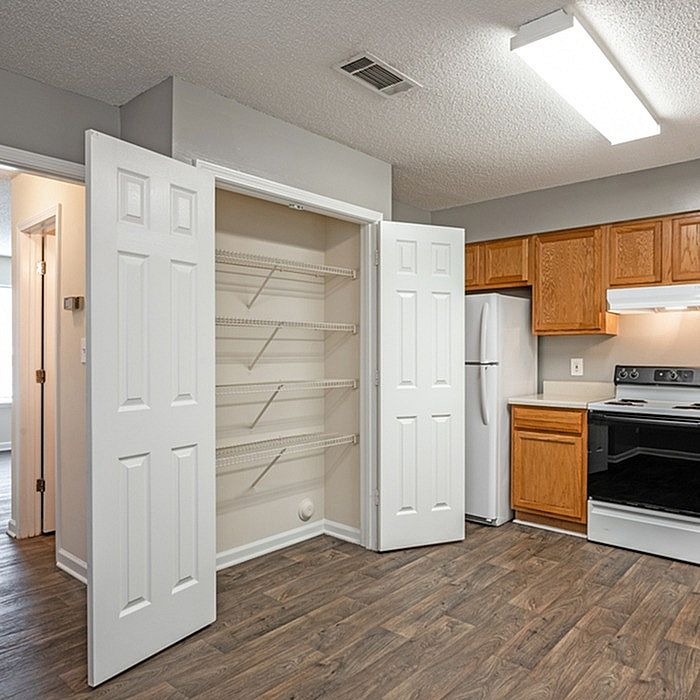 Modern kitchen with stylish cabinetry, spacious pantry, and sleek appliances, showcasing elegant wood flooring and ample natural light.