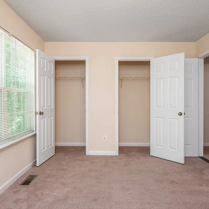 Bright and inviting bedroom with plush carpet and dual closets, offering ample storage space.