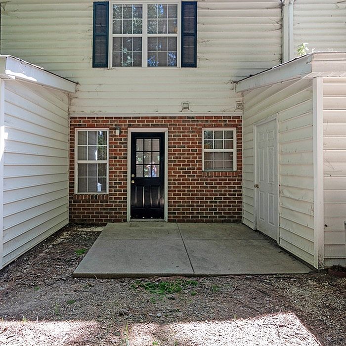 Inviting exterior showcasing brick and siding design with a charming entrance and large window above, ideal for natural light.