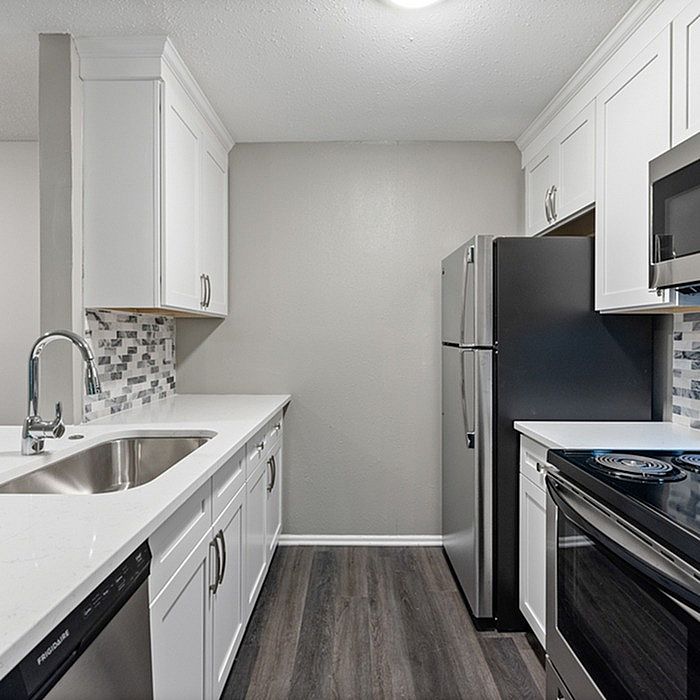 Modern kitchen with sleek stainless steel appliances, elegant white cabinetry, and stylish tile backsplash.