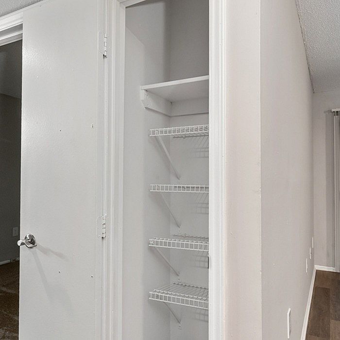 Modern apartment with a spacious utility closet featuring multiple shelves, perfect for organization.
