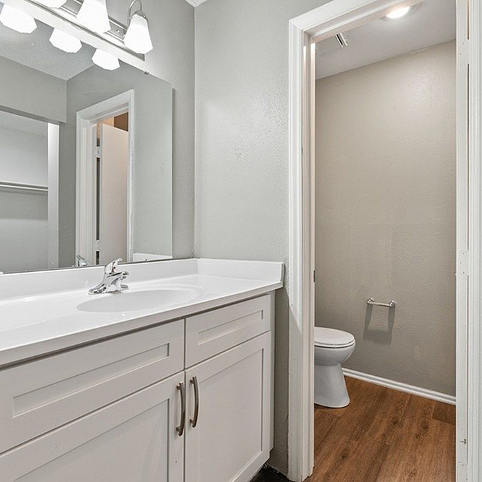 Elegant bathroom with modern vanity, large mirror, and stylish lighting.