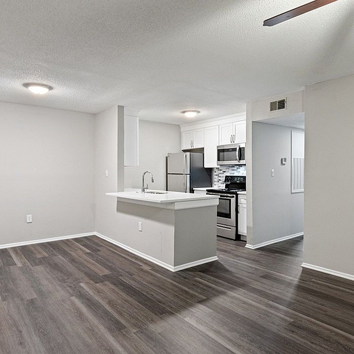Modern open-concept kitchen with stainless steel appliances and sleek hardwood flooring, perfect for contemporary living.