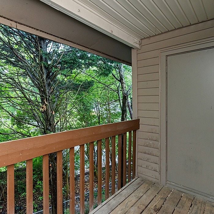 Charming balcony retreat with wooden railing overlooking lush greenery for a peaceful outdoor escape.