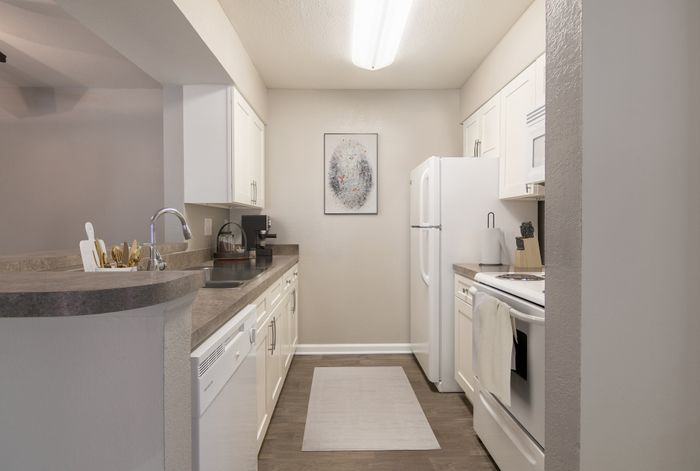 Modern kitchen with sleek countertops, white cabinetry, and chic decor, offering a bright and inviting atmosphere.