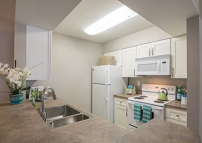 Bright and modern kitchen with white cabinetry, sleek countertops, and a cozy breakfast bar, perfect for culinary creativity.