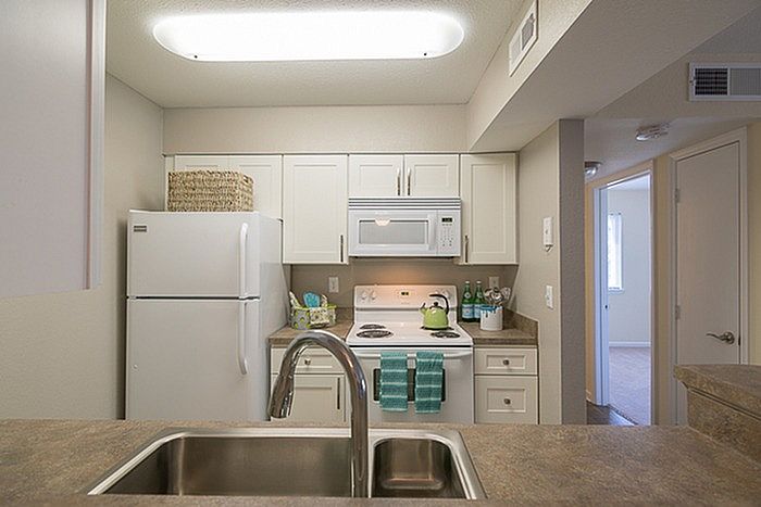 Modern kitchen with sleek countertops, white cabinets, and contemporary appliances, perfect for culinary enthusiasts.