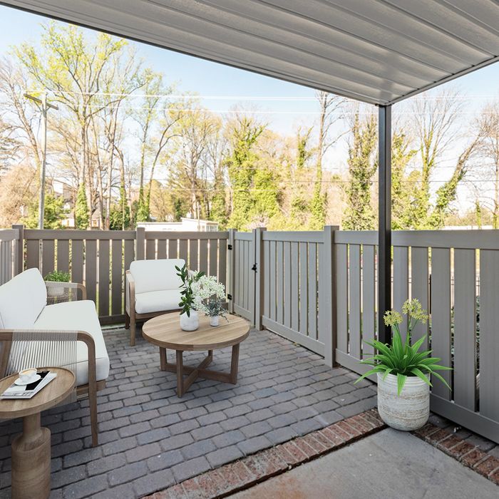 Inviting outdoor patio featuring elegant wicker furniture, lush greenery, and a cozy atmosphere perfect for relaxation.