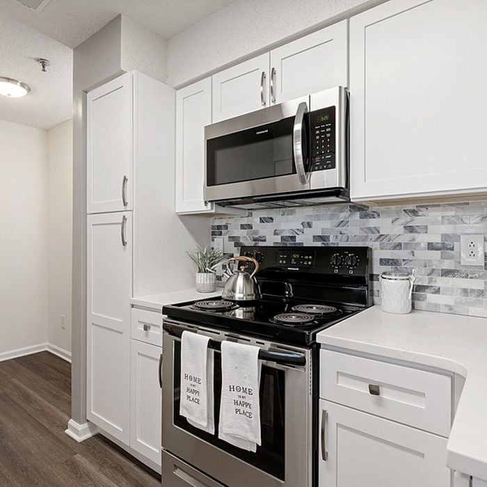 Modern kitchen with sleek white cabinets, stainless steel appliances, and elegant backsplash design.