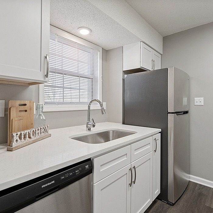 Chic and modern kitchen with sleek stainless steel appliances, elegant white cabinetry, and pristine countertops.