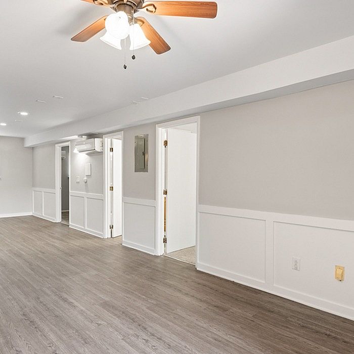 Modern and spacious interior with elegant wood flooring, neutral walls, and stylish ceiling fan, offering a clean and inviting atmosphere.
