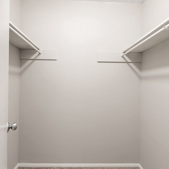 Spacious walk-in closet with neutral tones and ample shelving, ideal for stylish storage solutions.