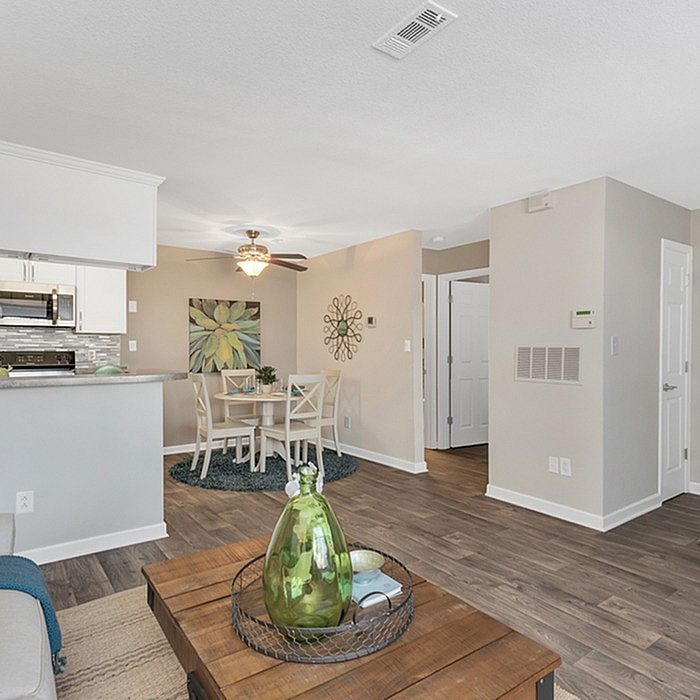 Bright and inviting open-concept living area with a modern kitchen, cozy dining space, and elegant hardwood floors.