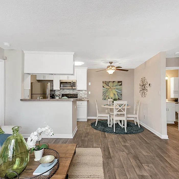 Inviting open-concept living area with a modern kitchen, elegant dining space, and warm wood flooring.