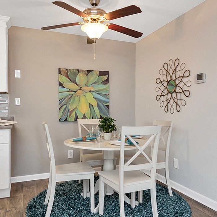Charming dining nook with a round table, four elegant chairs, and vibrant wall art, creating an inviting and cozy atmosphere.