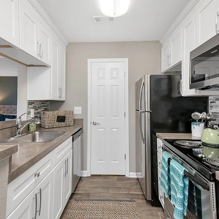 Elegant modern kitchen with stainless steel appliances, chic white cabinetry, and stylish backsplash, perfect for culinary creativity.