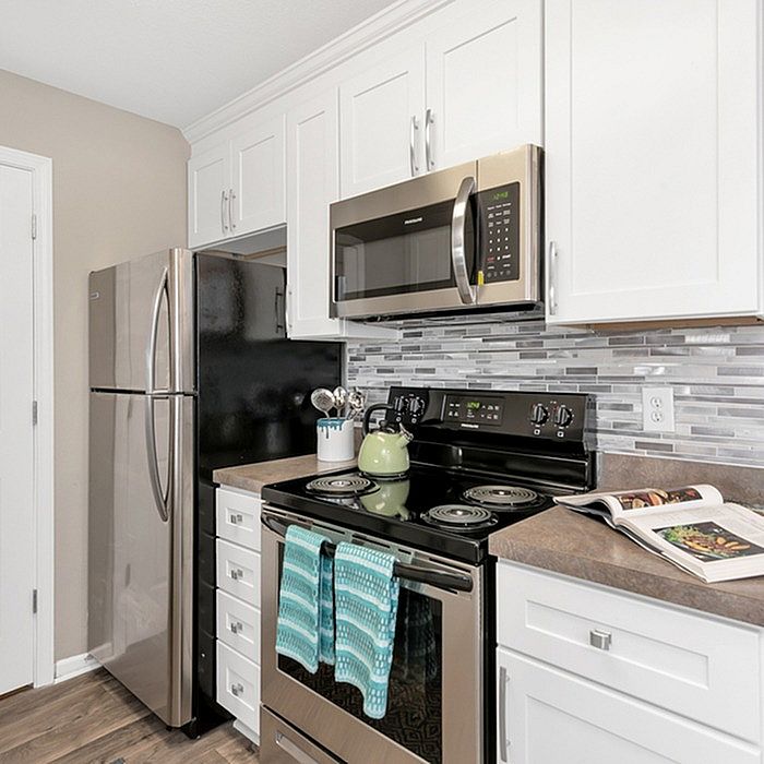 Modern kitchen with sleek stainless steel appliances, elegant white cabinetry, and stylish tiled backsplash.
