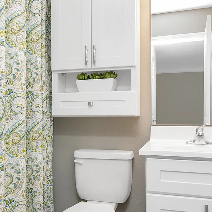 Chic bathroom design with modern white cabinets, elegant countertop, and decorative shower curtain adding a vibrant touch.