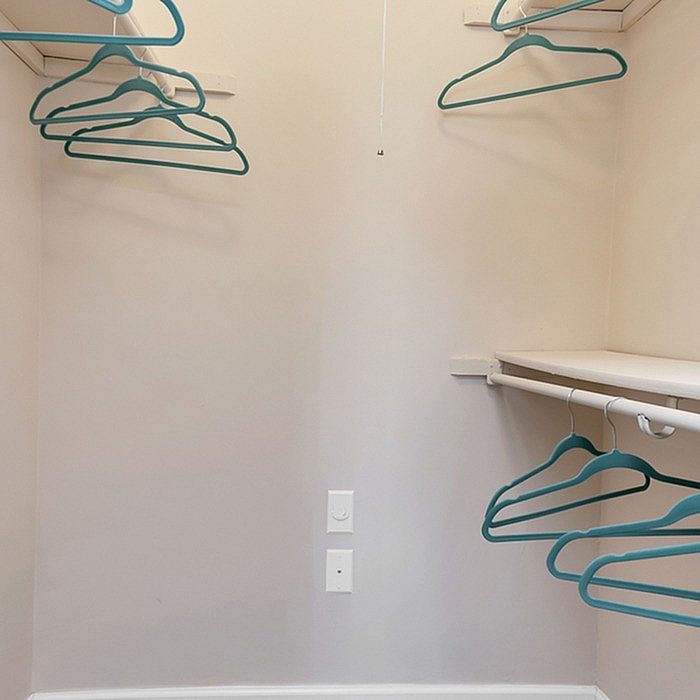 Spacious walk-in closet with modern shelving and teal hangers, offering ample storage in a stylish apartment.