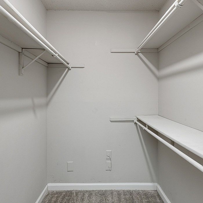 Spacious walk-in closet with built-in shelving and hanging rods, offering ample storage and organization options.