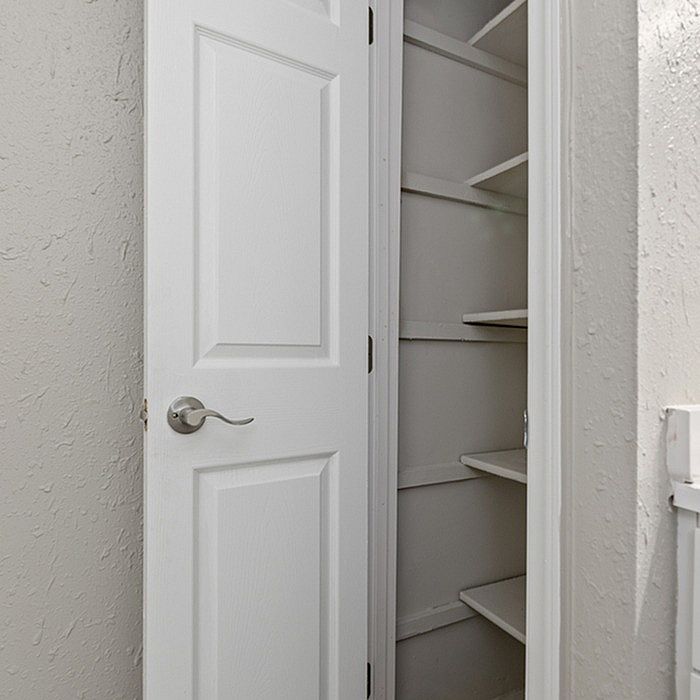 Elegant white closet with built-in shelves, perfect for organized storage solutions.