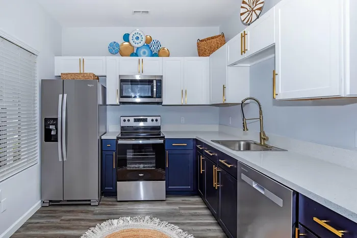 Modern kitchen with sleek appliances, elegant navy and white cabinetry, and stylish decor accents.