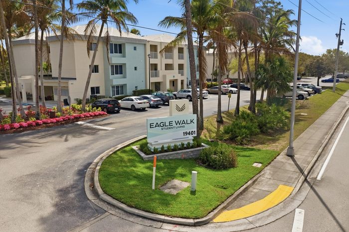 Charming Eagle Walk student living community surrounded by lush palm trees and vibrant landscaping, offering a modern and welcoming atmosphere.