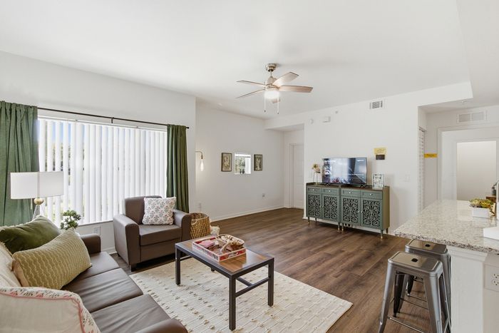 Bright and spacious living room with elegant decor, featuring a cozy seating area, stylish wooden flooring, and modern entertainment unit.