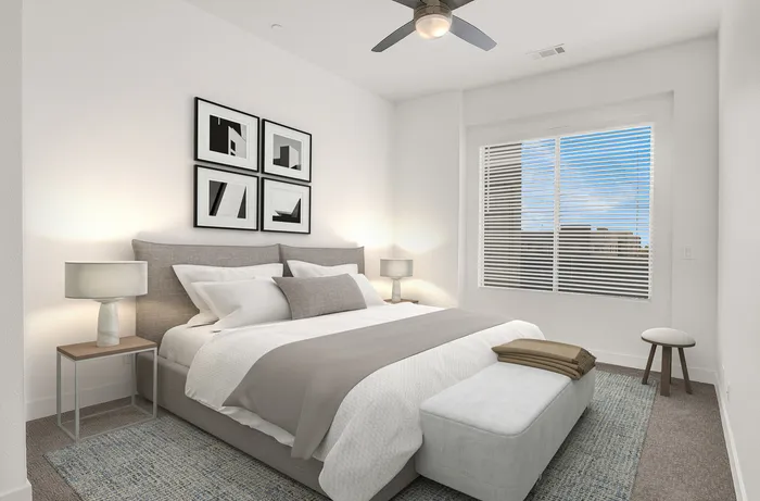 Elegantly styled bedroom featuring a plush bed, modern decor, and abundant natural light through large windows.
