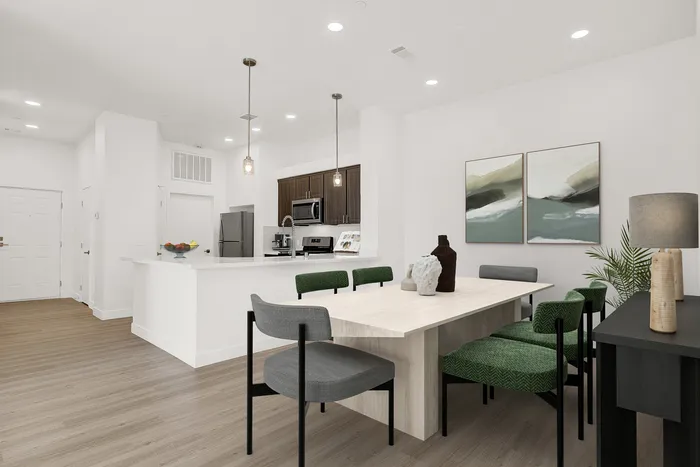 Contemporary open-concept dining and kitchen area with sleek modern finishes, elegant pendant lighting, and stylish decor.