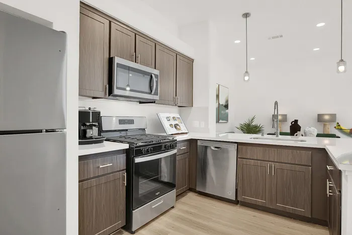 Modern kitchen with sleek stainless steel appliances, elegant wood cabinetry, and stylish pendant lighting exuding a contemporary charm.