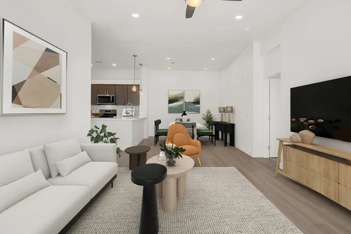 Elegant open-concept living space with modern furniture, cozy seating area, and stylish kitchen in the background.