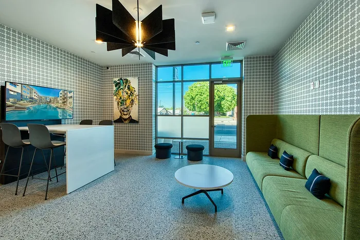 Contemporary apartment lounge with chic seating, modern artwork, and stylish lighting, perfect for relaxation and social gatherings.