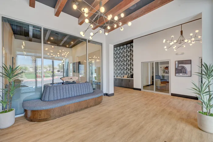 Sophisticated lobby featuring modern lighting, wood accents, and elegant seating with floor-to-ceiling glass windows.