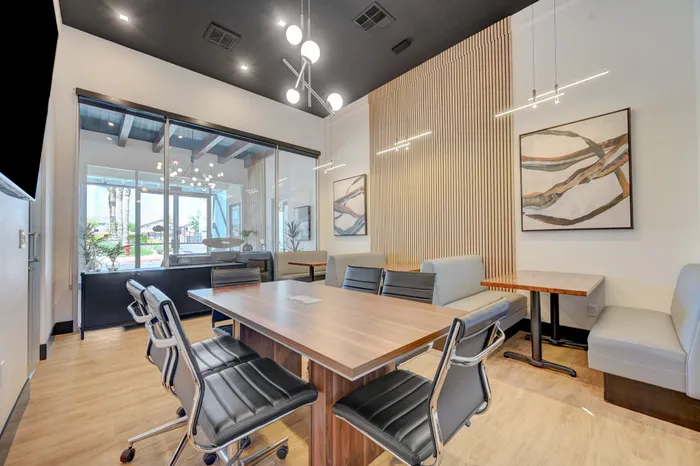 Modern conference room with sleek black chairs, wooden table, and stylish lighting, perfect for professional meetings.