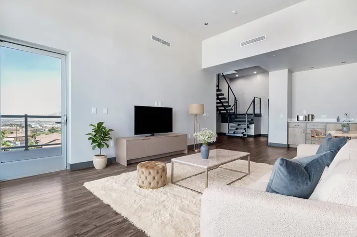 Elegant modern living room with cozy seating, sleek minimalist design, and a stunning view through large windows.