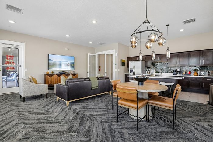 Modern open-concept living room and kitchen with elegant dark wood cabinetry, chic dining area, and cozy seating arrangement perfect for entertaining.