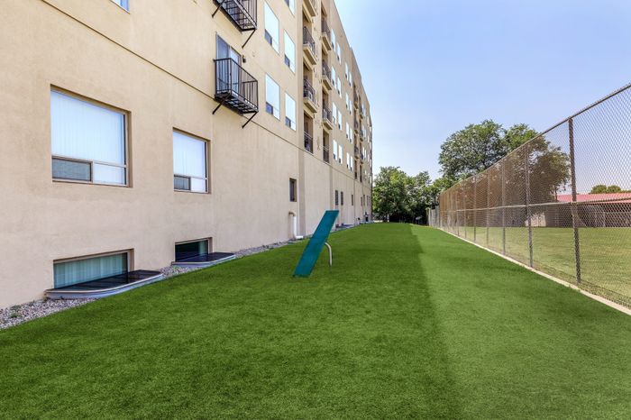 Inviting apartment exterior featuring a well-maintained green lawn and modern architecture, perfect for outdoor relaxation.