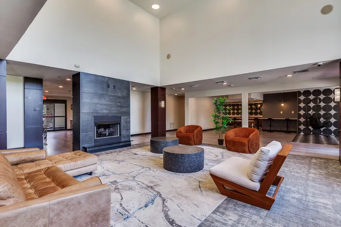Large lobby area with modern chairs, lounge seating, circular tables, a fireplace, and decorative accents.
