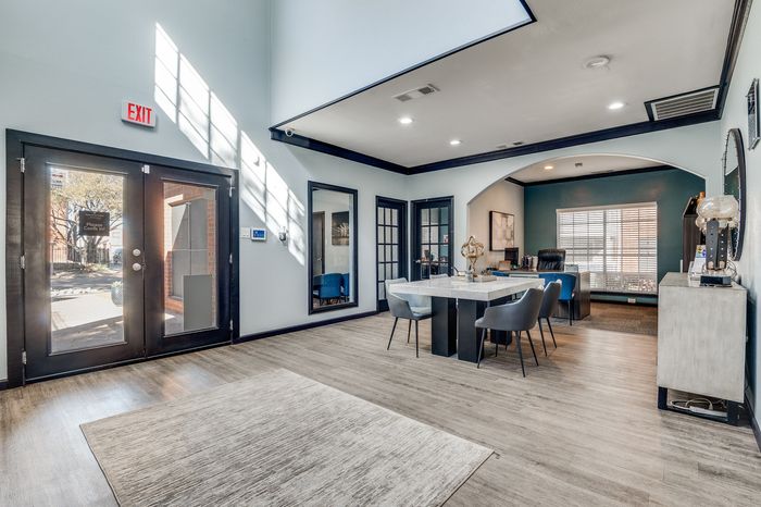 Bright leasing office entry at Preferred Place with seating and large double doors.