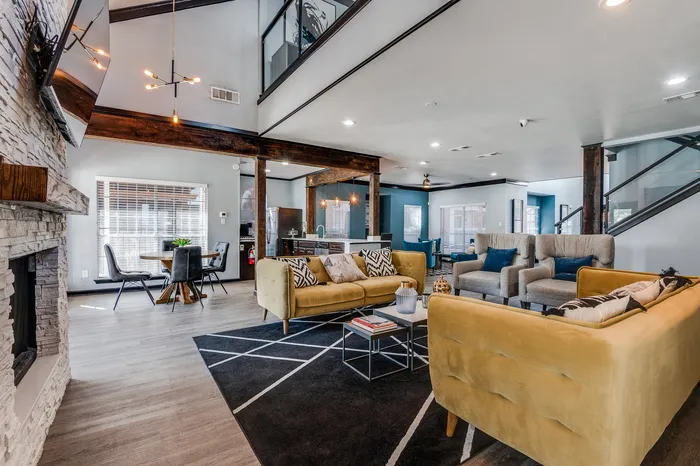 A large community clubhouse with seating areas, tables, and an open layout featuring modern d&eacute;cor and natural light.