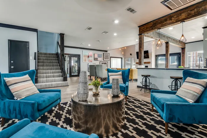 A shared clubhouse lounge with seating areas, bar-style stools, and access to other community amenities.