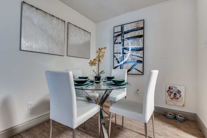 Dining nook with glass table and chairs in a bright apartment.