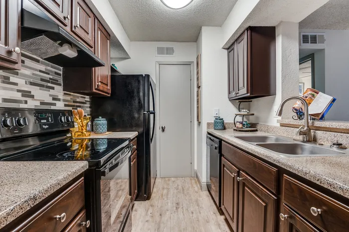 Kitchen with dark wood cabinets, standard appliances, and a pass-through counter design.
